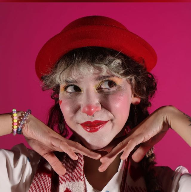 Filomena caracterizada de palhaça com chapéu vermelho